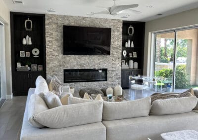 Modern home design Livingroom with sectional sofa, rug, and custom fireplace with stone and glass.