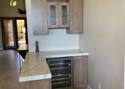 Home remodel wine bar featuring beautiful white stone countertops and elegant cabinets made of wood