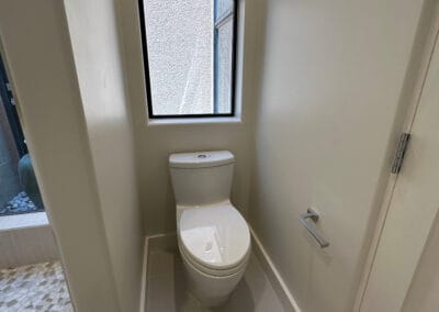 Image features an upgraded bathroom remodel with toilet and flooring upgrades.