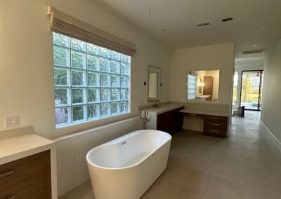 Elegant and modern master bathroom remodel with big white freestanding tub. Gorgeous white stone backsplash and chrome faucet.