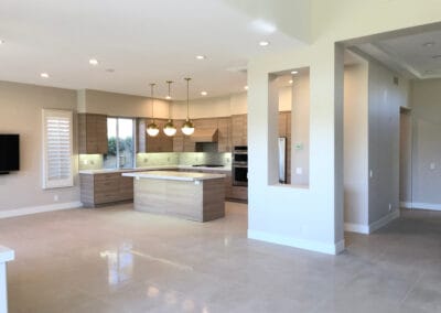 Elegant and modern kitchen design with stylish lighting, wooden finish cabinets, and upgraded countertops, island, and backsplash.