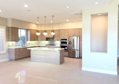 Elegant and modern kitchen design with stylish lighting, wooden finish cabinets, and upgraded countertops, island, and backsplash.