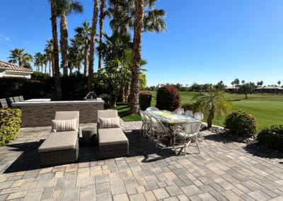 Stunning backyard BBQ and patio made of stone. Outdoor furniture sits on the patio overlooking the country club golf course.