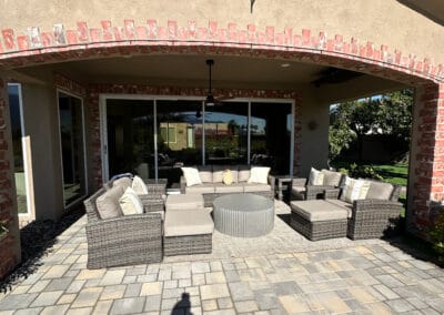 decretive brick archway featured in stone patio with patio furniture.