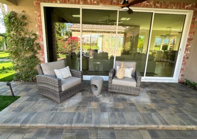 decretive brick sliding window featured in stone patio with patio furniture.