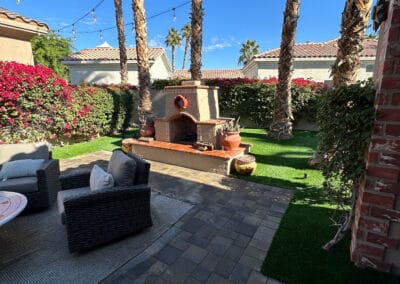 Backyard upgrade features a stone patio with an upgraded fireplace.