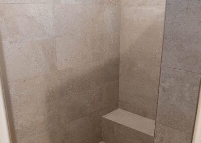 Gorgeous shower remodel featuring large tile walls and small square tile flooring.