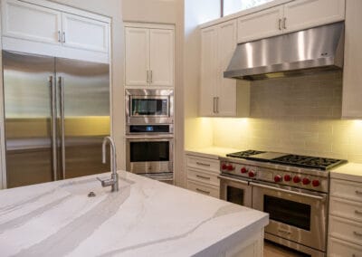 Stunning and elegant home interior design. Beautiful kitchen with upgraded white cabinets, countertops, and backsplash. Wolf stovetop and industrial hood.