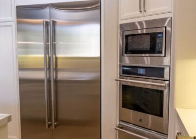 Elegant complete kitchen remodel featured in home renovation. Custom white cabinets, countertops, and wood flooring